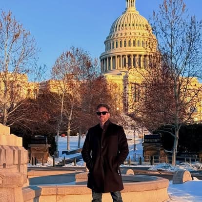 Efrain Gomez Jr. standing outdoors in front of the United States Capitol on a snowy winter day