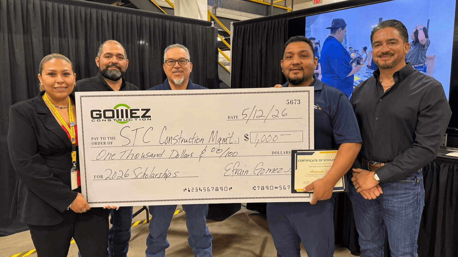 Efrain Gomez Jr. with South Texas College staff and a scholarship recipient holding an oversized Gomez Construction scholarship check